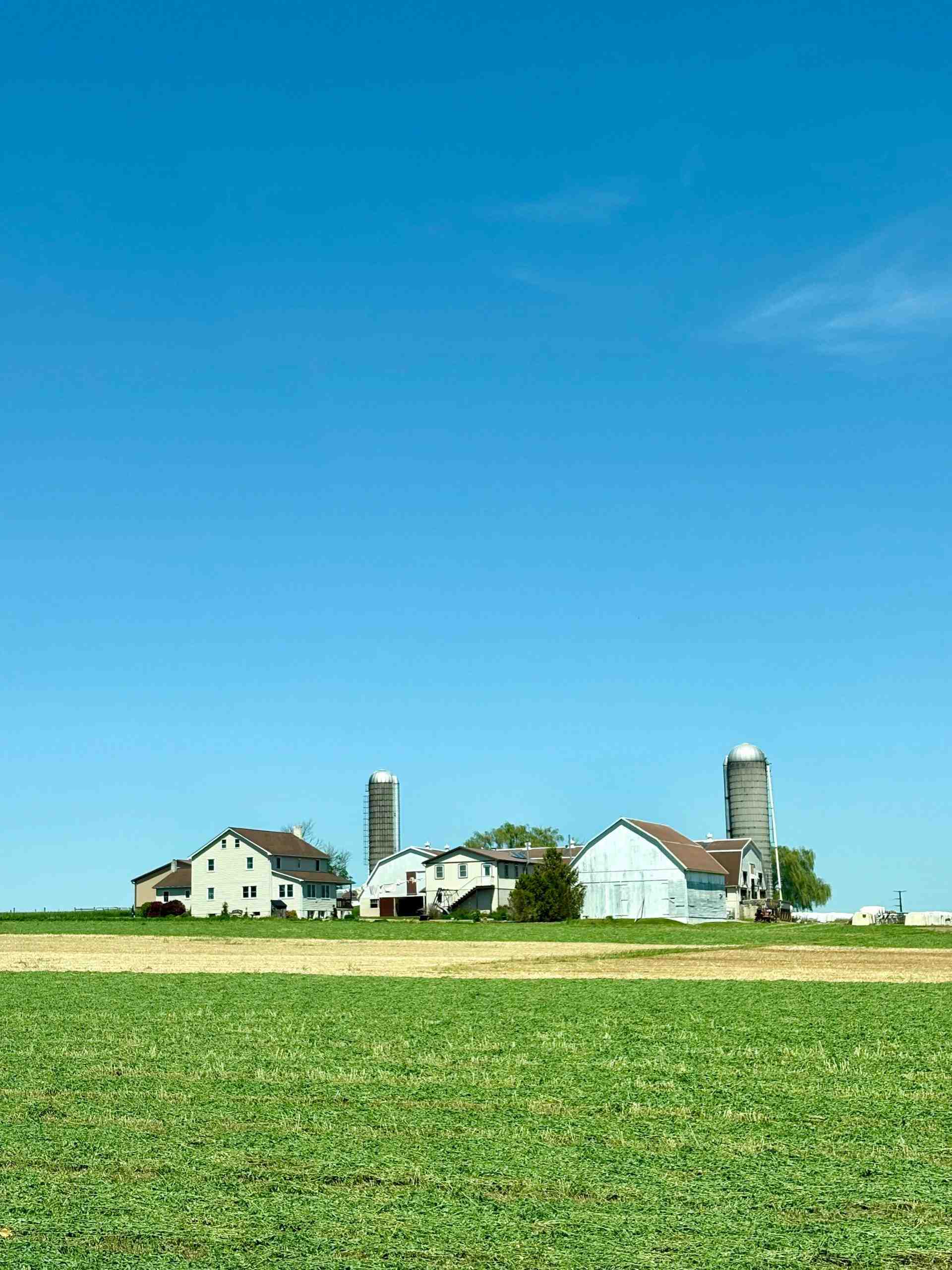 Large family farm with barns, silos, and cultivated fields, representing Crop financing, used farm equipment financing, how to finance a farm expansion, agricultural operating capital, and soybean financing that help producers invest in land, equipment, and seasonal farming operations.